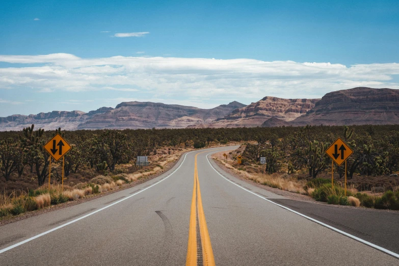 a road in the middle of a desert with mountains in the background, by Lee Loughridge, pexels contest winner, background image, moab, wide roads, thumbnail