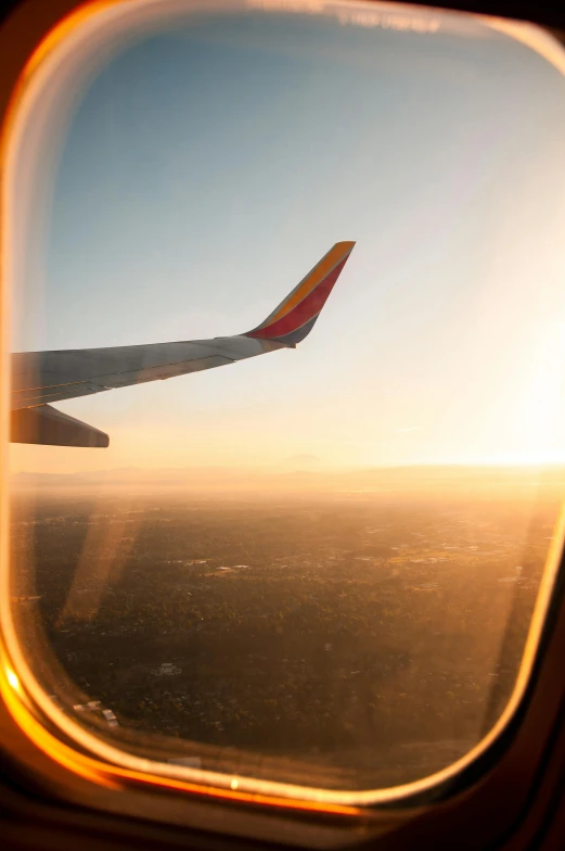 a view out of an airplane window at sunset, happening, yellow and red color scheme, boeing 737 cabin, clear skies, a wooden