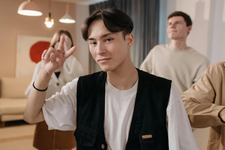 a group of people standing in a living room, trending on pexels, hyperrealism, peace sign, attractive young man, asian human, with high cheekbones