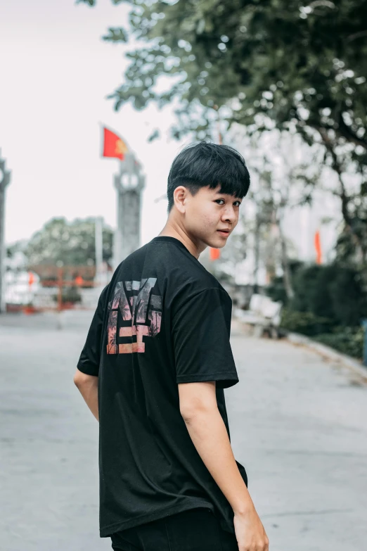 a young man riding a skateboard down a street, inspired by Gang Hui-an, lyco art, black t-shirt, profile image, vietnam, view from back