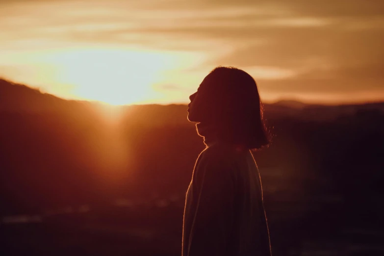 a person standing in front of a sunset, woman's face looking off camera, chillhop, uncropped, frank moth