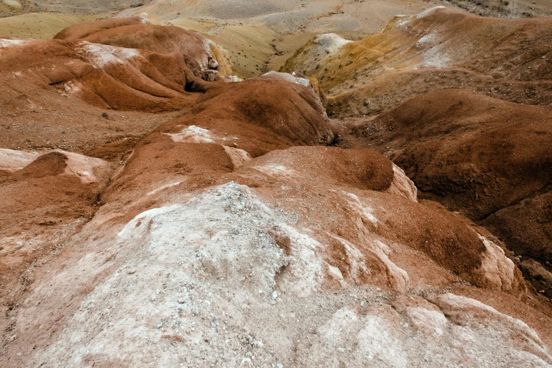 a group of people standing on top of a mountain, by Julia Pishtar, trending on unsplash, color field, rotting clay skin, red brown and white color scheme, mineral collections, thumbnail