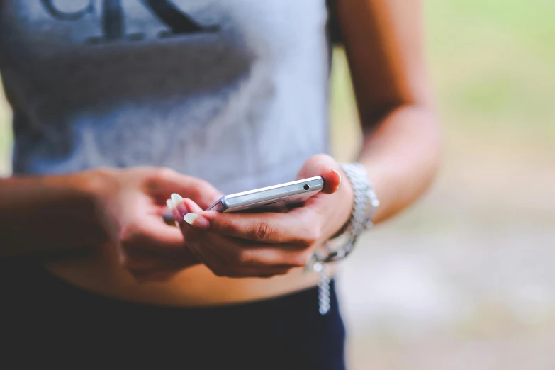 a close up of a person holding a cell phone, trending on pexels, photo of young woman, body shot, in 2 0 1 5, messages