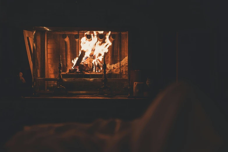 a person laying in front of a fire in a fireplace, inspired by Elsa Bleda, pexels contest winner, cozy bed, open window at night, warm wood, (fire)