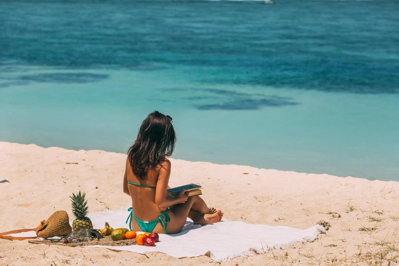 a woman sitting on the beach reading a book, by Julia Pishtar, pexels contest winner, tropical style, tanned skin, snacks, moana