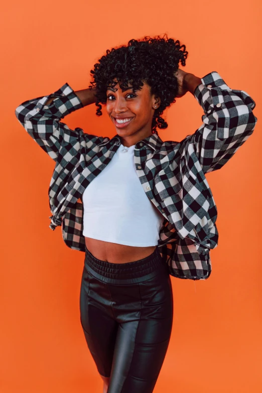 a woman posing in front of an orange background, flannel, super cute funky black girl, black on white background, leathery