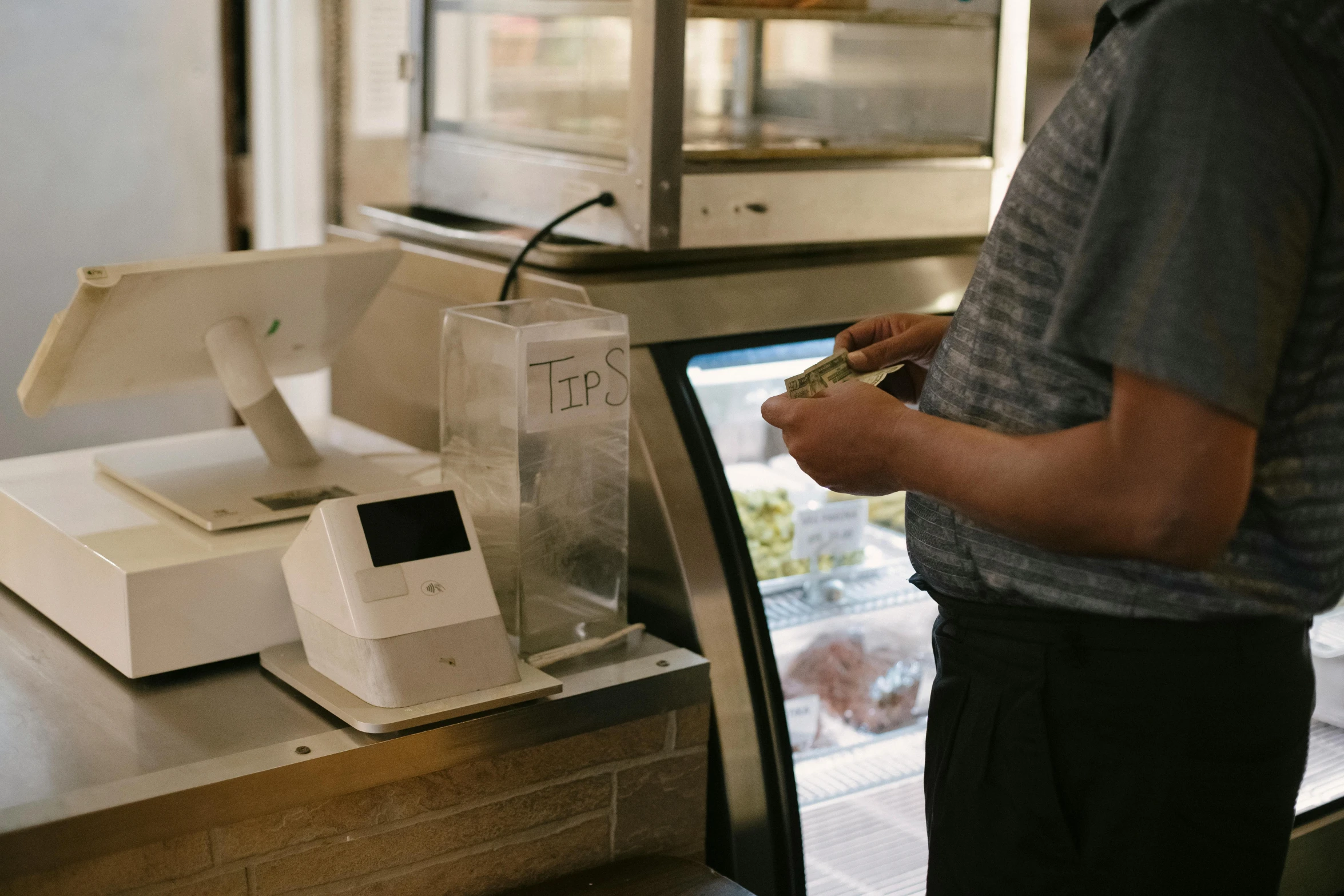 a man standing in front of a cash register, unsplash, ice cream on the side, ignant, a friendly wisp, high resolution photo