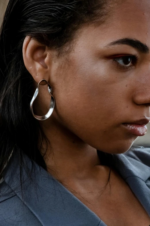 a close up of a person with a cell phone, an album cover, by Nina Hamnett, happening, thin round earrings, wavy, silver, dark skinned