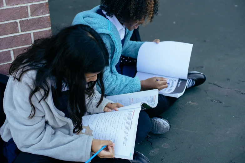 a couple of girls sitting next to each other on the ground, trending on unsplash, ashcan school, holding notebook, on medium grade paper, uncropped, profile image