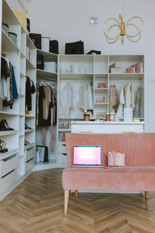 a pink couch sitting in a living room next to a closet, a photo, by Niko Henrichon, trending on pexels, casual white garment, store, home office, rectangle