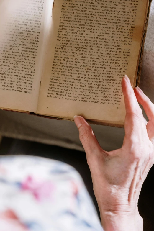 a close up of a person holding an open book, old lady, passages, overlooking, biodiversity heritage library