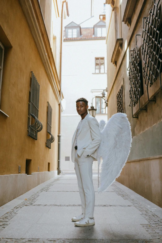 a man in a white suit holding an umbrella, pexels contest winner, renaissance, silver angel wings, brown skinned, vouge italy, instagram model