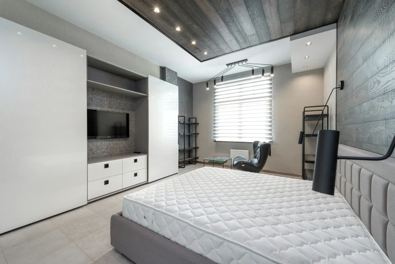 a bed sitting inside of a bedroom next to a tv, by Adam Marczyński, pexels contest winner, office ceiling panels, white and grey, designer furniture, clean 4 k