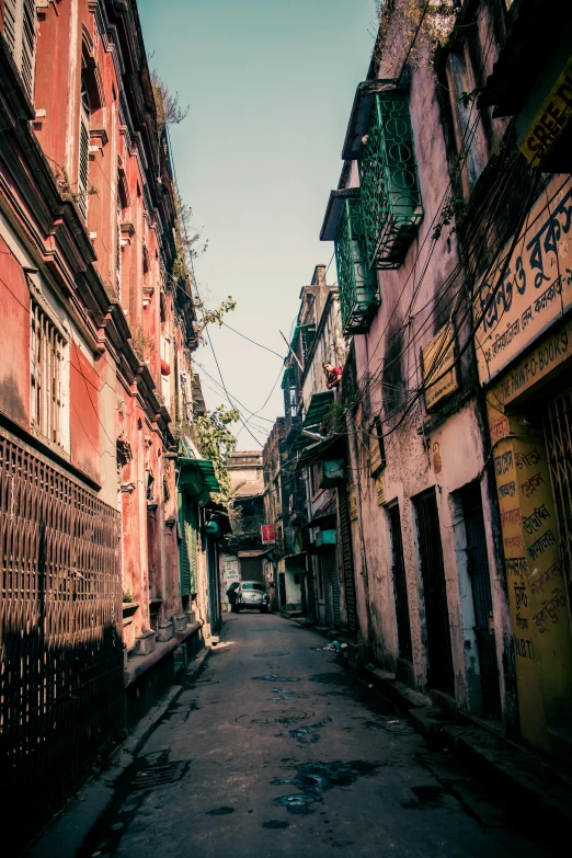 a narrow street is lined with old buildings, an album cover, pexels contest winner, bengal school of art, faded colors, city view, a quaint, sunlit