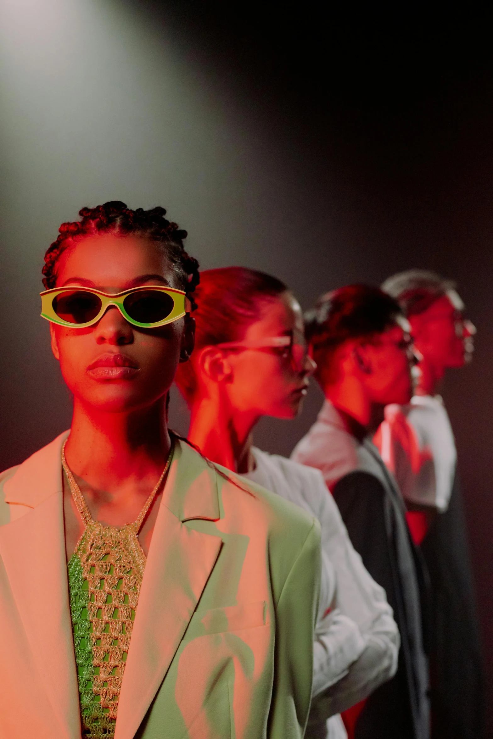 a group of men standing next to each other on a stage, trending on pexels, afrofuturism, fashion model in sunglasses, photo of a black woman, glowing green neon eyes, androgynous person