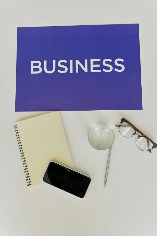 a blue business sign sitting on top of a white table, a picture, trending on pexels, private press, educational supplies, square, various items, full body image