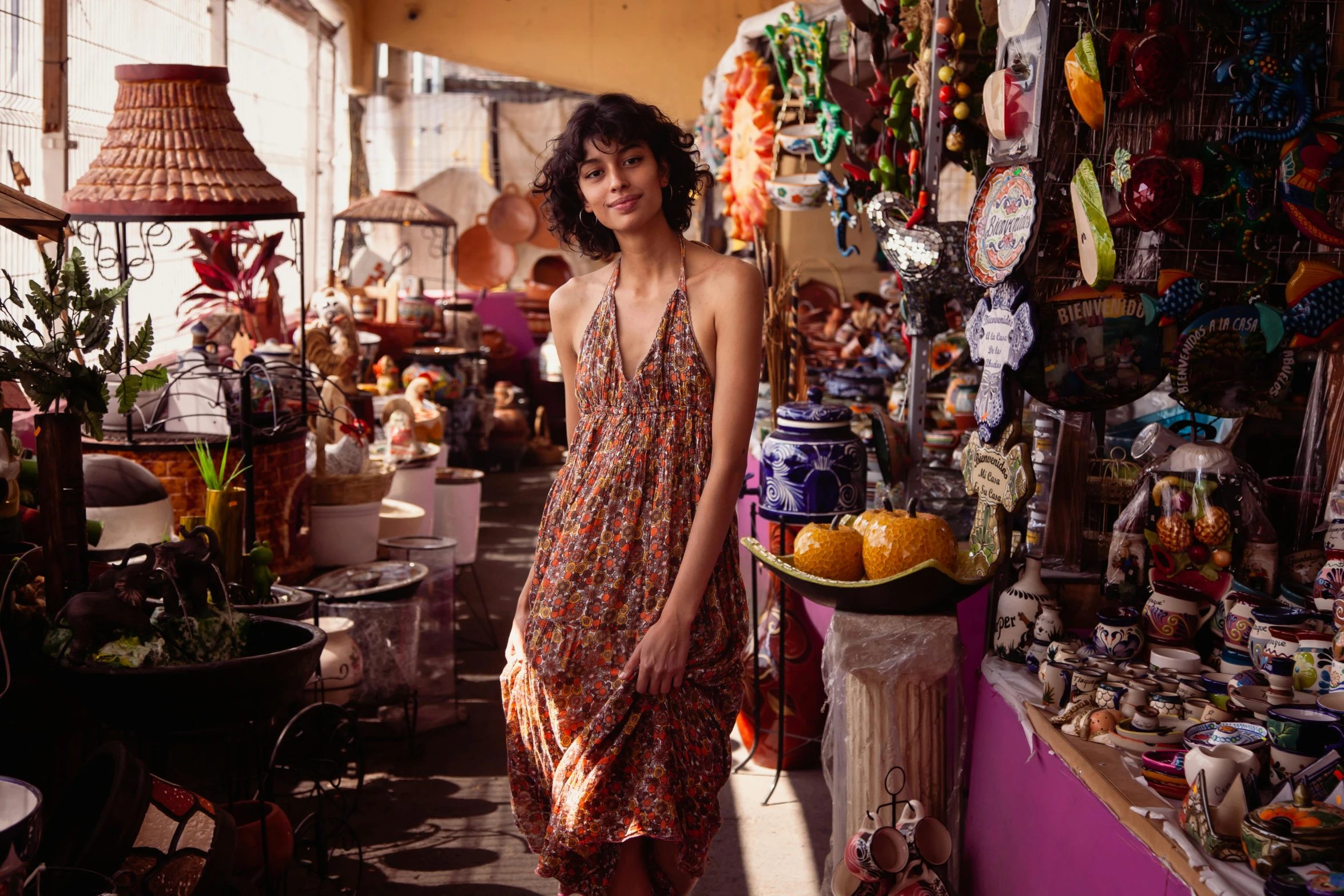 a woman in a dress standing in a store, pexels contest winner, justina blakeney, market setting, amber, summer day