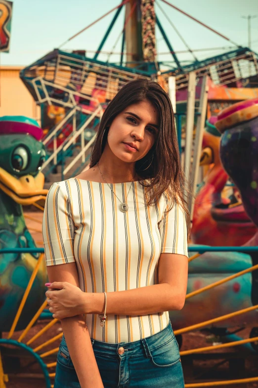 a woman standing in front of a carnival ride, inspired by Elsa Bleda, pexels contest winner, graffiti, portrait of alexandra daddario, striped shirt, alanis guillen, handsome girl