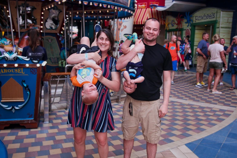 a man standing next to a woman holding a baby, unsplash, incoherents, theme park, conjoined twins, avatar image, group photo