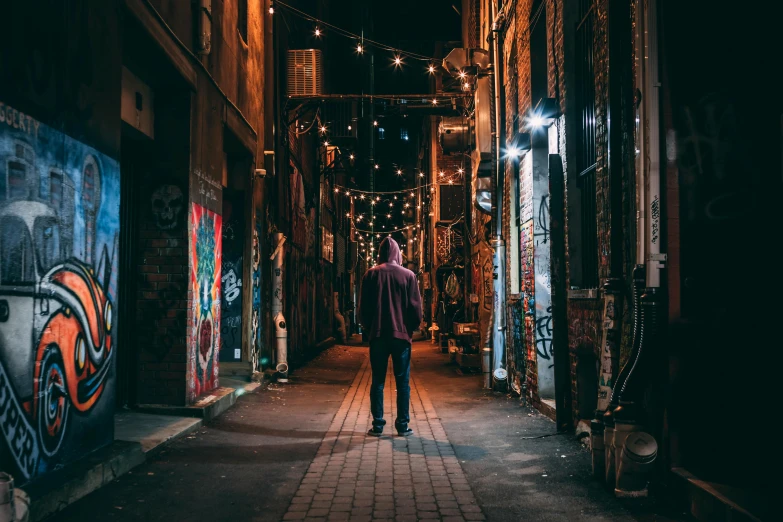 a man riding a skateboard down a street at night, pexels contest winner, street art, standing in an alleyway, north melbourne street, cozy lights, a person standing in front of a