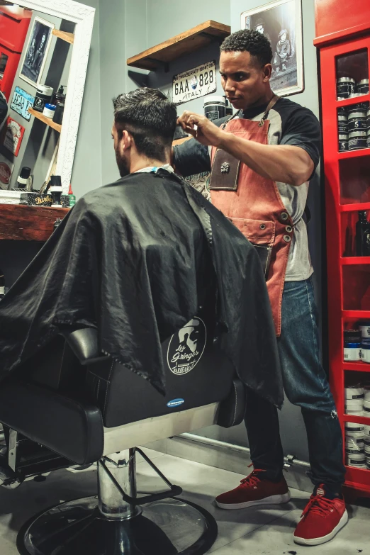 a barber cutting a man's hair in a barber shop, vantablack cape, facing away, colour corrected, sitting down