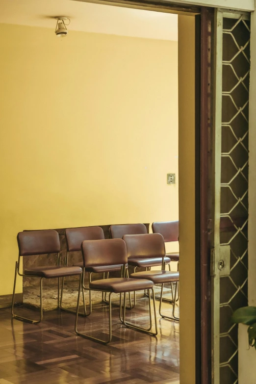 a room that has a bunch of chairs in it, by Giorgio De Vincenzi, modernism, ocher details, door, ochre, top