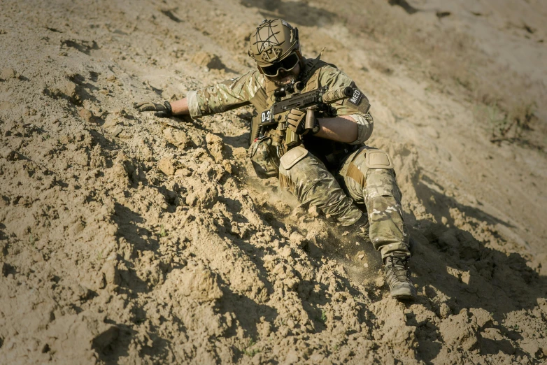 a soldier kneeling in the sand with a rifle, body armour, operation highjump, a high angle shot, shot with sony alpha