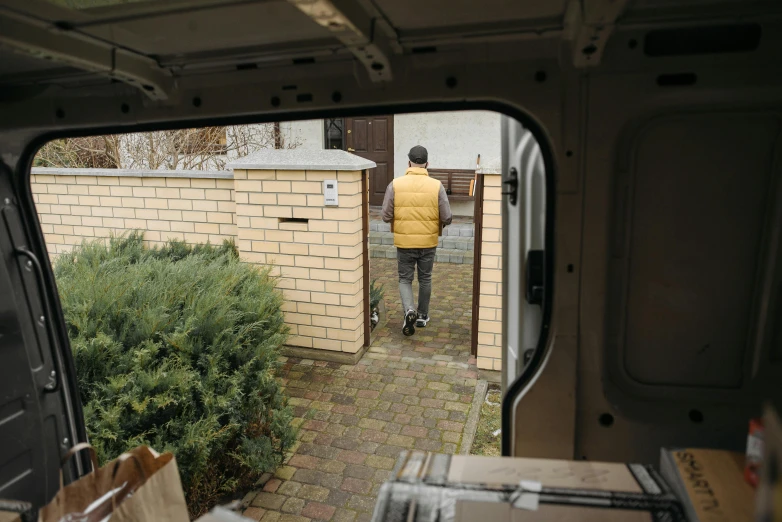 a man that is standing in the back of a van, small path up to door, gettyimages, cardboard, maintenance photo