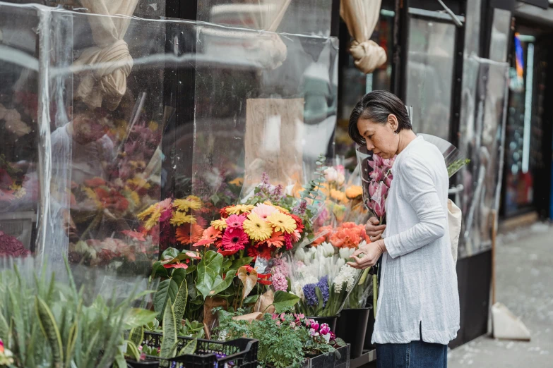 a woman standing in front of a flower shop, trending on unsplash, fan favorite, comforting and familiar, city views, longque chen