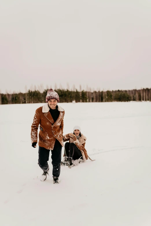 a woman walking a dog across a snow covered field, by Christen Dalsgaard, pexels contest winner, folk art, happy couple, tubing, instagram story, brown