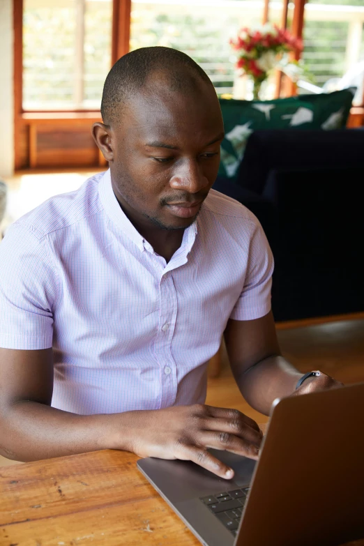 a man sitting at a table using a laptop computer, emmanuel shiru, thumbnail, young adult male, multiple stories