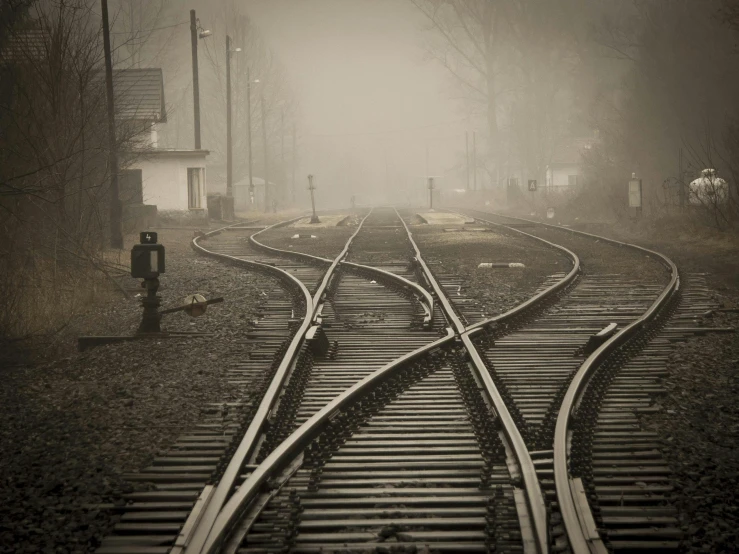 a black and white photo of a train track, by Lucia Peka, realism, ((mist)), sepia photography, gray, intersection