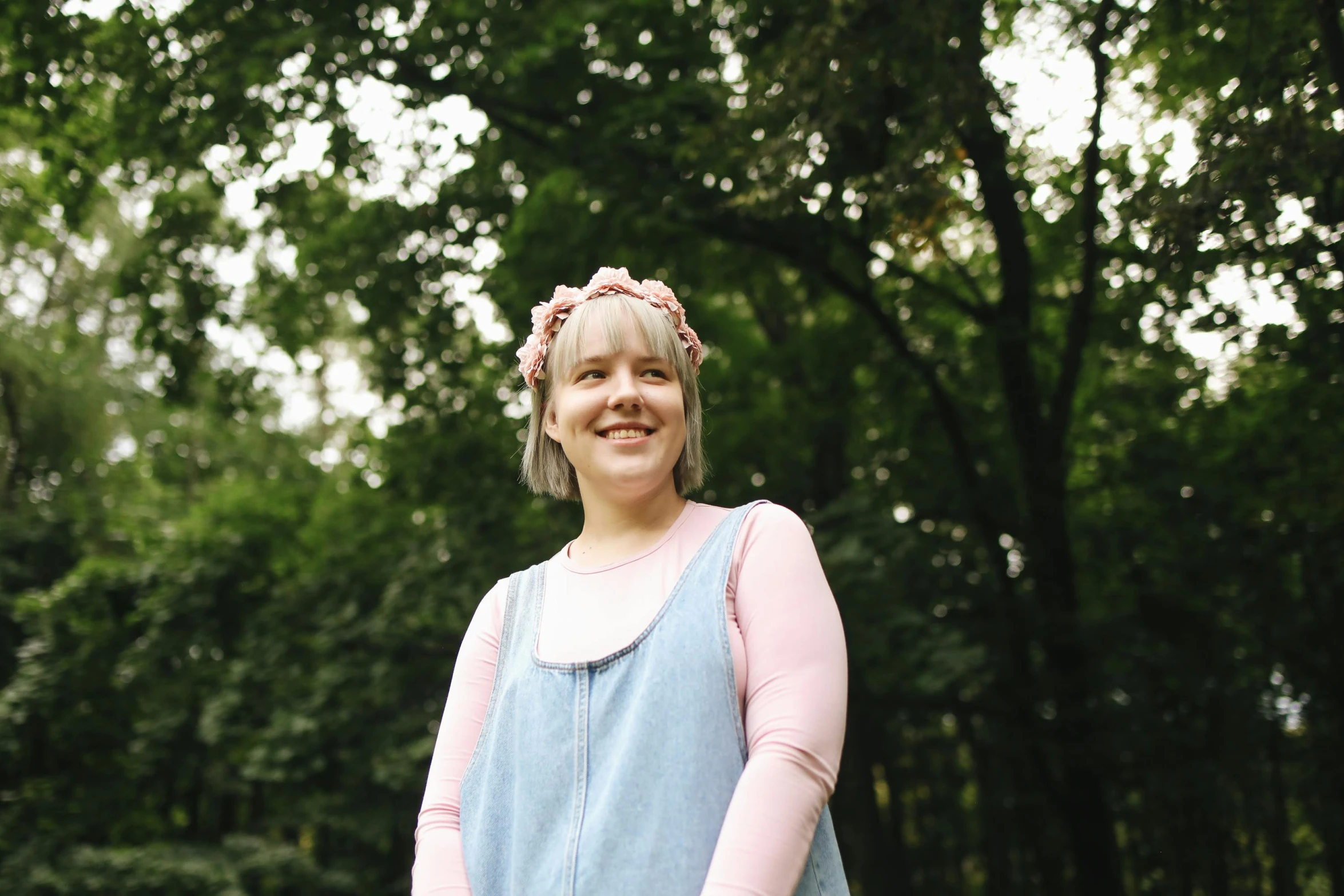 a woman standing in a field with a frisbee, inspired by Elsa Beskow, unsplash, wearing a pink head band, portrait image, wearing overalls, wearing a laurel wreath