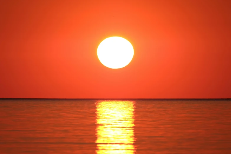 the sun is setting over the water, pexels, big red sun, halogen, orange, digital photo