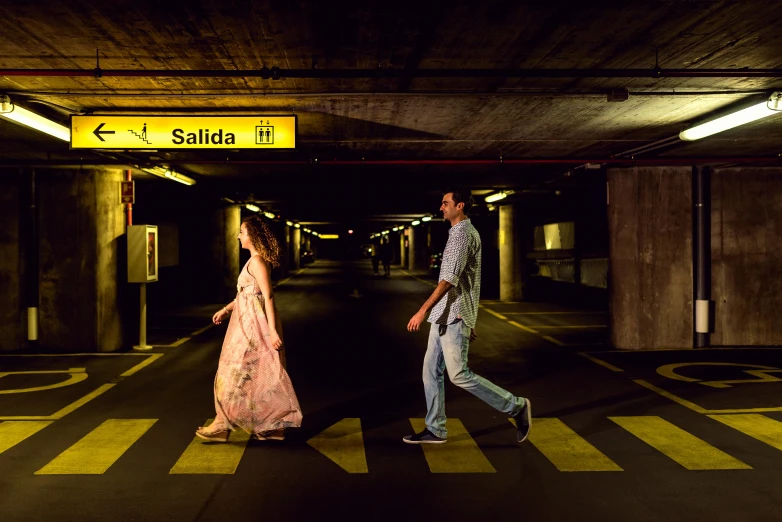 a man and a woman walking through a parking garage, an album cover, by Lucia Peka, pexels contest winner, in spain, summer evening, people on the ground, lightroom preset