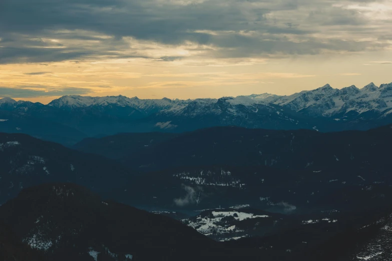 a person standing on top of a snow covered mountain, pexels contest winner, renaissance, overcast dusk, whistler, sunset in a valley, view from high