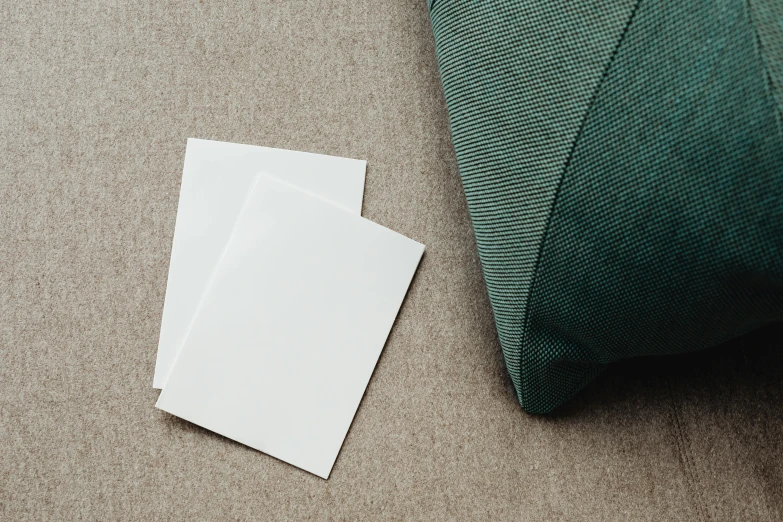 a piece of paper laying on the floor next to a pillow, unsplash, private press, card template, couch, placards, double layer fold over hem