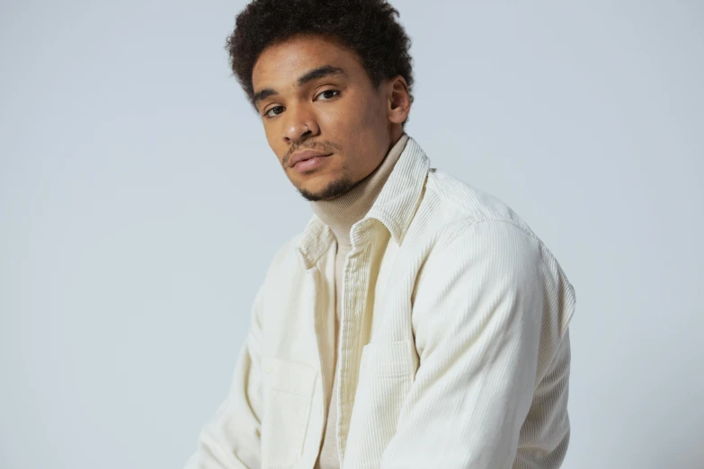 a man in a white shirt poses for a picture, an album cover, inspired by Theo Constanté, trending on pexels, tessa thompson, medium portrait soft light, ochre, clean background trending