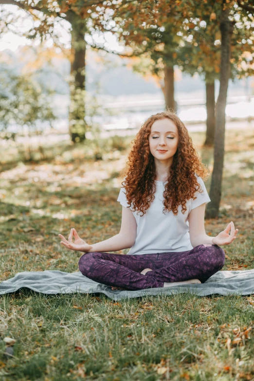 a woman sitting on a blanket in a park doing yoga, a portrait, trending on pexels, renaissance, curly red hair, square, low quality photo, teenage girl