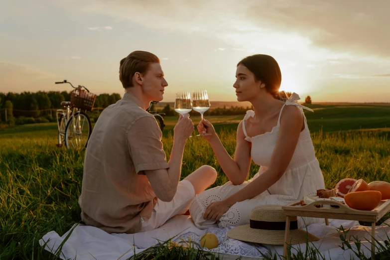 a man and a woman sitting on a blanket in a field, holding glass of wine, sunset raked lighting, jordan grimmer and natasha tan, having a picnic