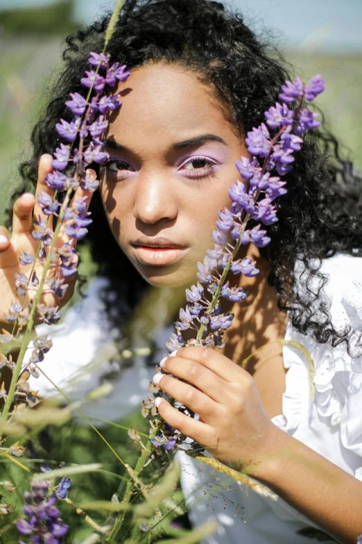 a woman standing in a field of purple flowers, an album cover, trending on pexels, renaissance, black teenage girl, close-up shoot, salvia, sitting down