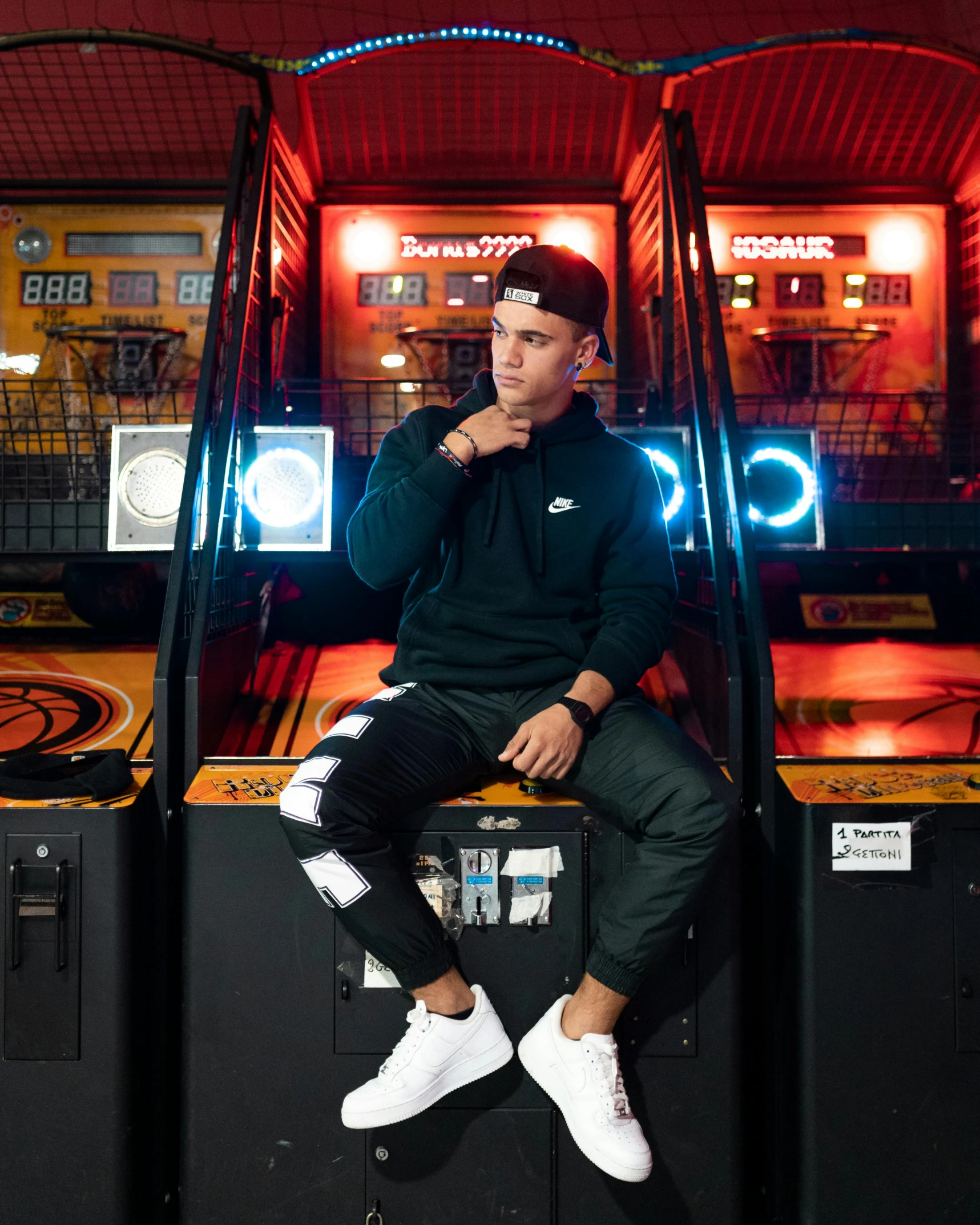 a man sitting on top of a game machine, bad bunny, casual black clothing, mall background, profile image