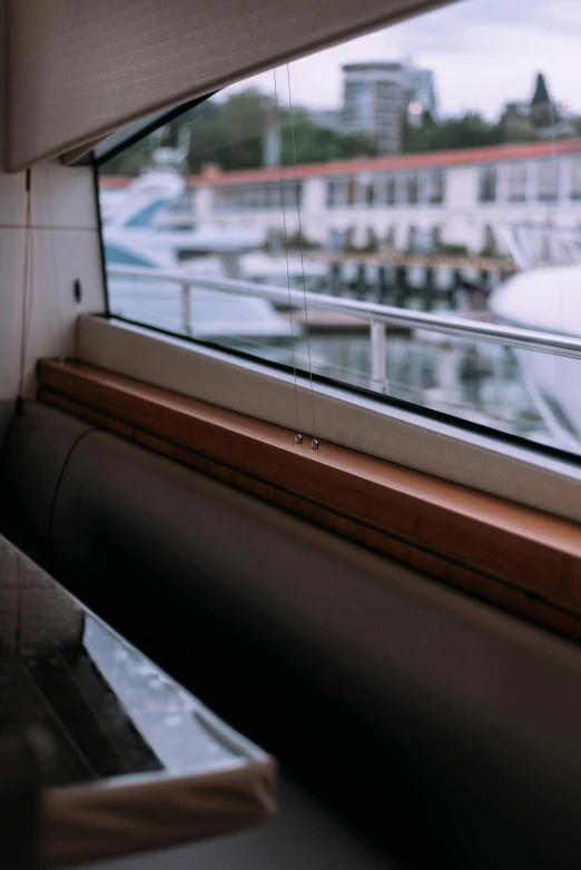 a close up of a window with a boat in the background, a picture, unsplash, modernism, large pipes, awnings, wooden trim, on a super yacht