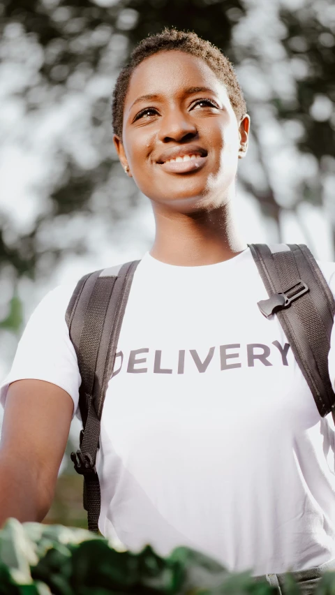 a woman with a backpack smiles at the camera, trending on pexels, hurufiyya, logo for lunch delivery, t - shirt, dark skinned, thumbnail