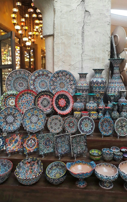 a table topped with lots of plates and bowls, a mosaic, inside an arabian market bazaar, photo taken in 2018, bargello, intricate oils