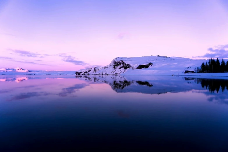 a body of water with a mountain in the background, by Peter Churcher, pexels contest winner, romanticism, white and purple, luminist polar landscape, blue sunset, mirrored