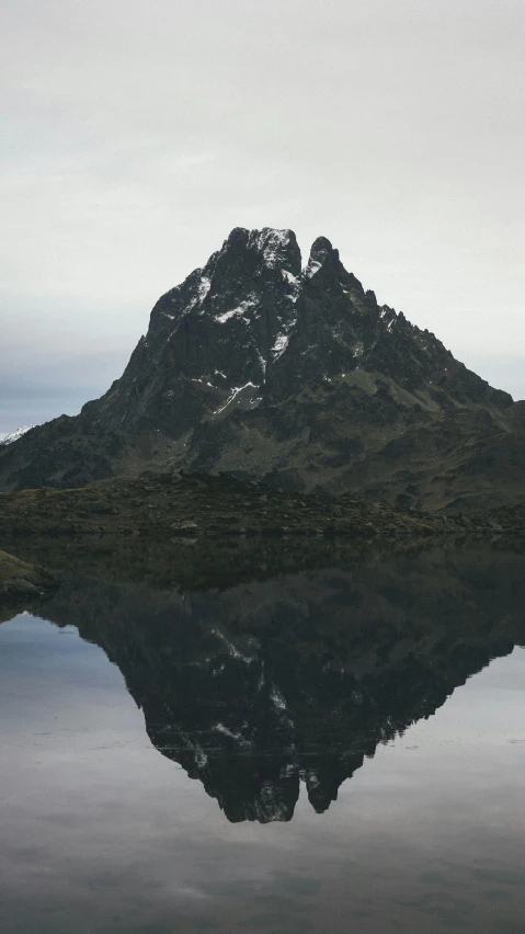 a body of water with a mountain in the background, mirror like water, devil's horns, photographed for reuters, te pae