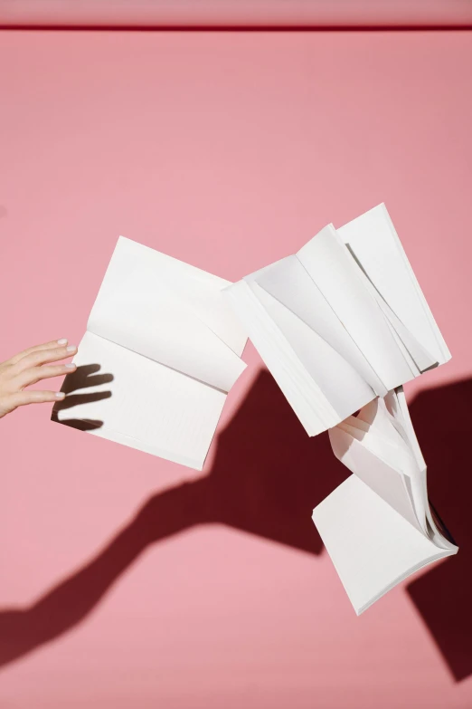 a person holding a sheet of paper in one hand and a sheet of paper in the other, an album cover, by Alexis Grimou, pexels contest winner, books flying around, white long gloves, taejune kim, kailee mandel