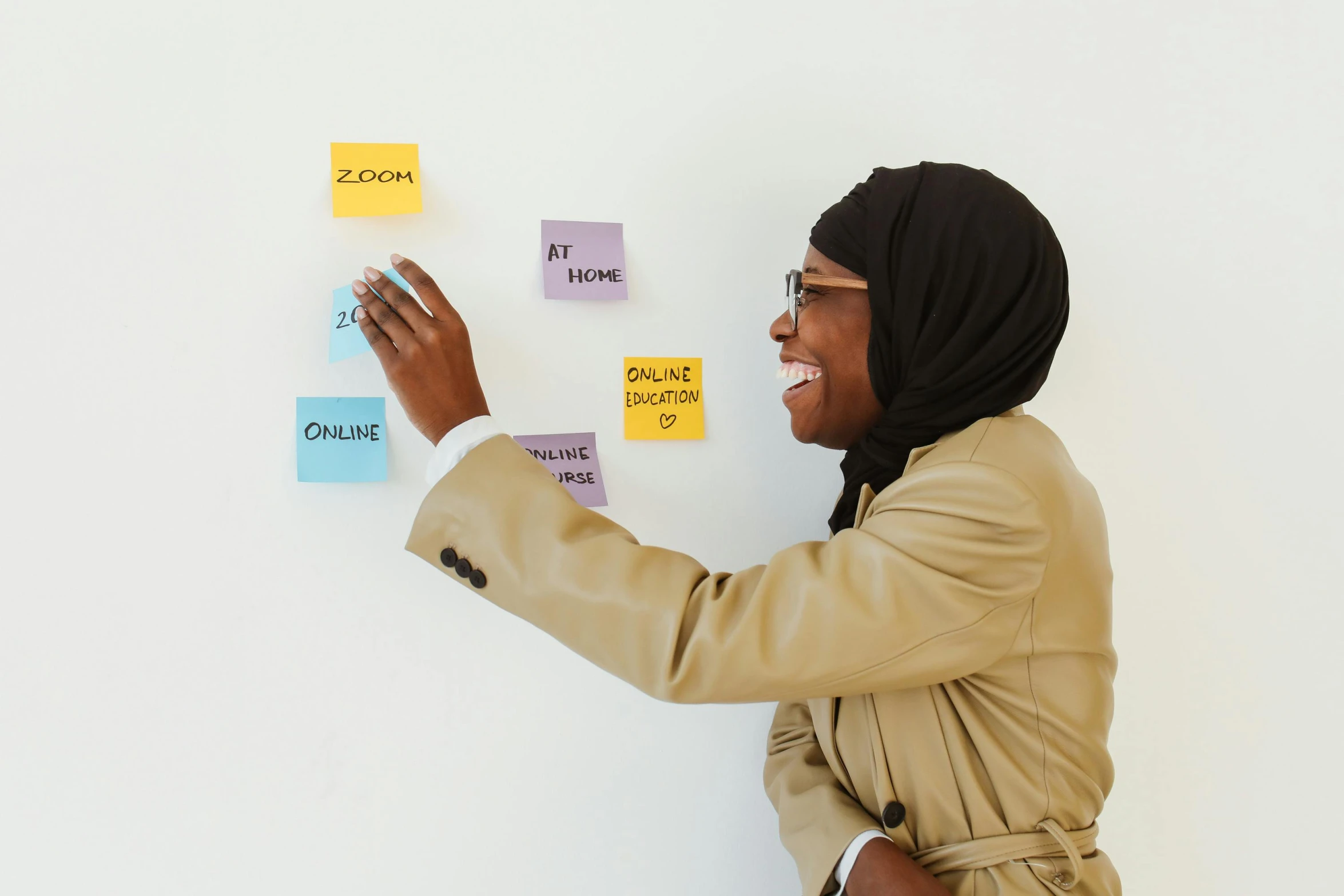 a woman standing in front of a wall covered in post it notes, african ameera al taweel, mobile learning app prototype, with a white background, background image