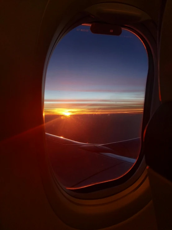 the sun is setting through the window of an airplane, pexels contest winner, red and orange glow, taken in 2022, profile picture 1024px, wide high angle view